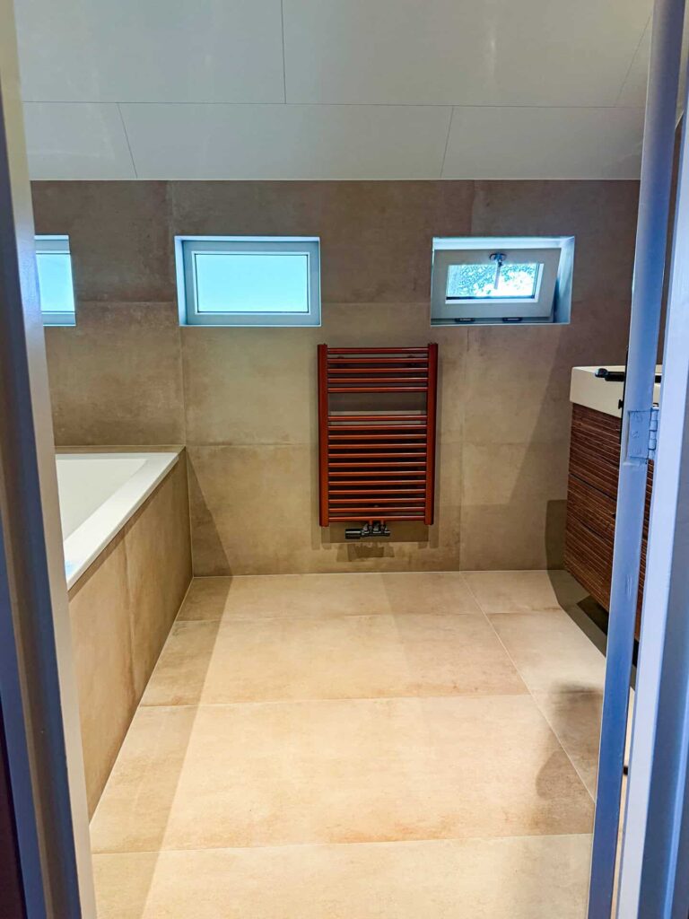 Landelijk toilet met beige tegels en koperkleurige details