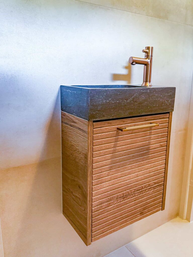 Toiletmeubel met hardstenen blad en koperkleurige kraan