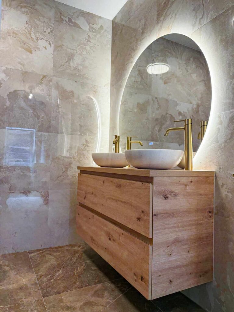 Hotel-chique badkamer met verlichte ronde spiegel