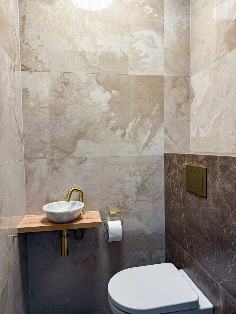 Apart toilet met marmerlook tegels en matgouden details